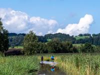 Radfahrer durchqueren den gefluteten Weg nahe Felden